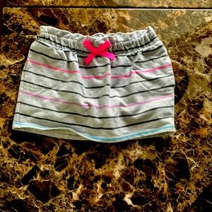 A gray skort with black pink, purple and blue stripes